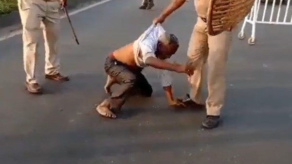 রাস্তার ধারে এক বৃদ্ধ বাম সমর্থককে ধরে পুলিশের লাথি