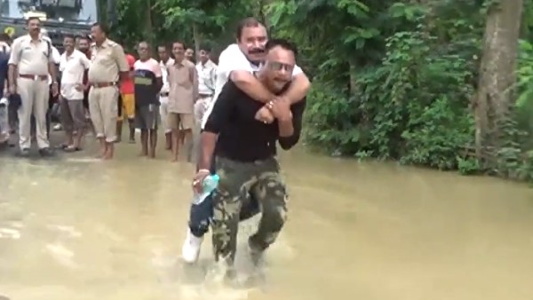 বন্যা কবলিত এলাকা দেখতে এসে উদ্ধারকর্মীর পিঠে চড়ে জল পেরোলেন অসমের বিজেপি বিধায়ক বন্যা কবলিত এলাকা দেখতে এসে উদ্ধারকর্মীর পিঠে চড়ে জল পেরোলেন অসমের বিজেপি বিধায়ক